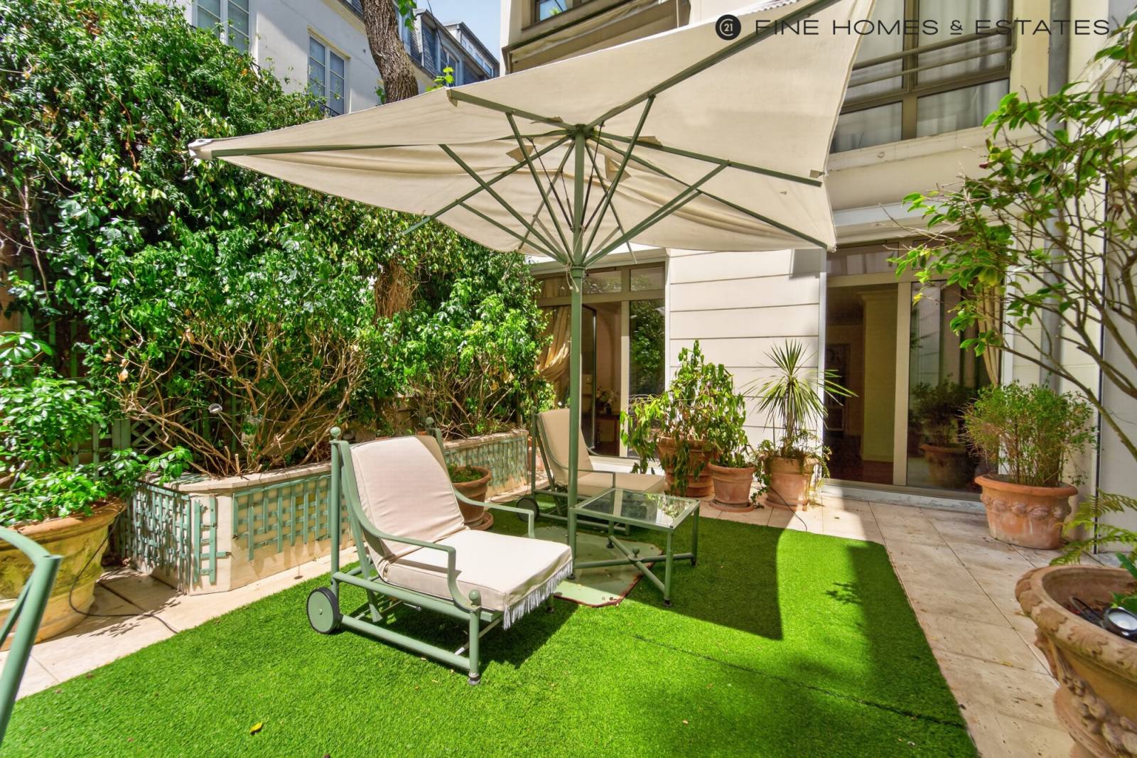 Terrasse généreuse intégrée à un environnement verdoyant, valorisant l’élégance discrète de cette adresse emblématique de Saint-Germain-des-Prés raffiné.