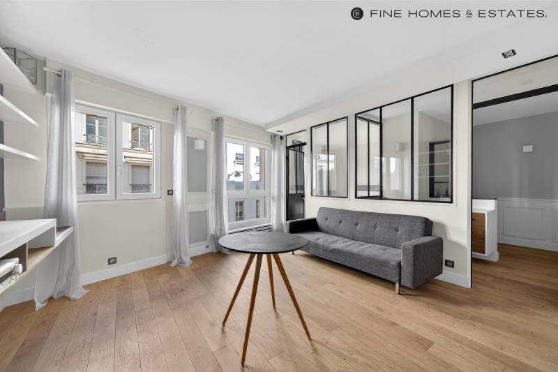 Séjour lumineux avec coin cuisine entièrement équipé au cœur d’un appartement recherché par agence immobilière Paris 6.