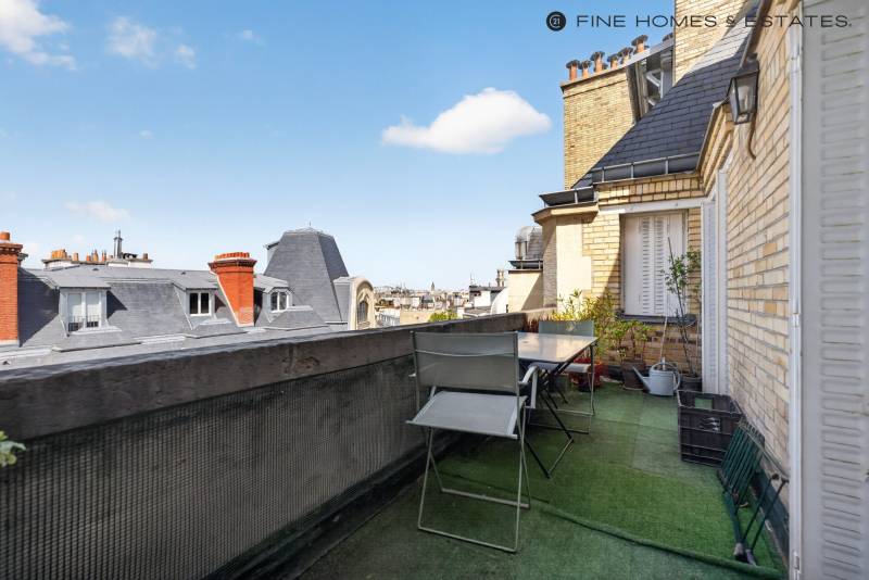 Terrasse élégante accessible depuis les espaces de réception, dans un immeuble ancien remarquable du quartier Notre-Dame-des-Champs parisien prestigieux.