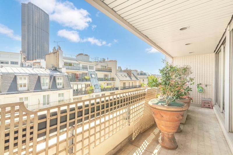 Terrasse lumineuse offrant une ouverture plein sud et dévoilant des vues spectaculaires sur Paris et les Invalides.