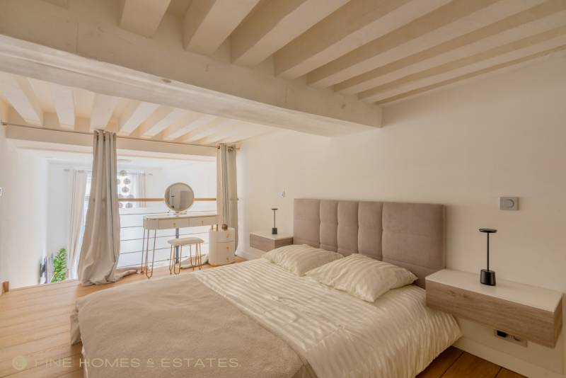 Espace nuit en mezzanine conjuguant intimité, volumes généreux et rénovation raffinée au cœur du sixième arrondissement parisien.
