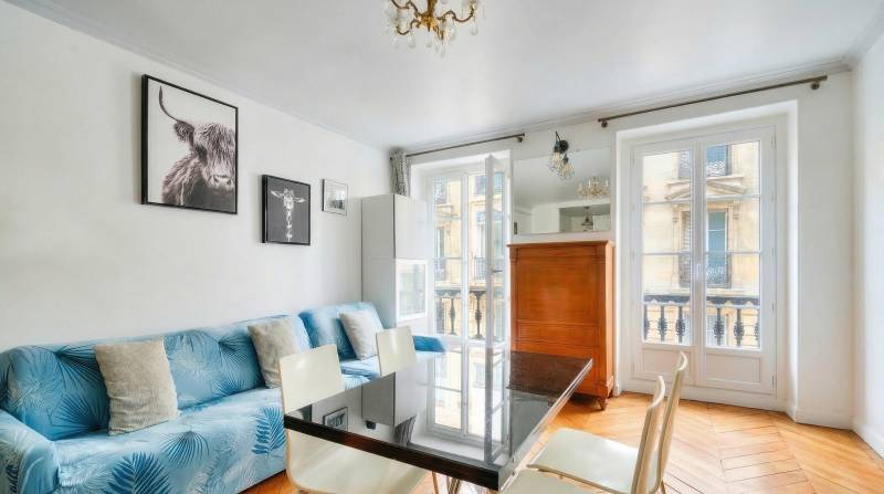 Séjour avec cuisine ouverte, parquet ancien et double exposition Est-Ouest, dans un appartement familial au cœur du quartier Sorbonne.