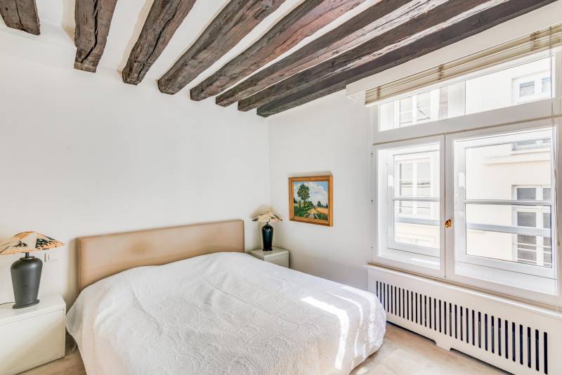 Chambre paisible dotée d’un dressing attenant offrant un espace nuit élégant apprécié par notre agence immobilière Paris 6.